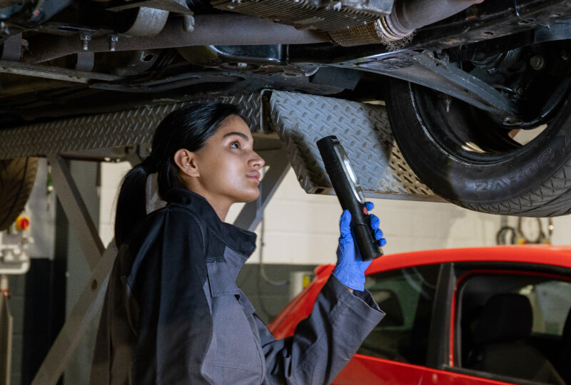 Female Technican looking at car