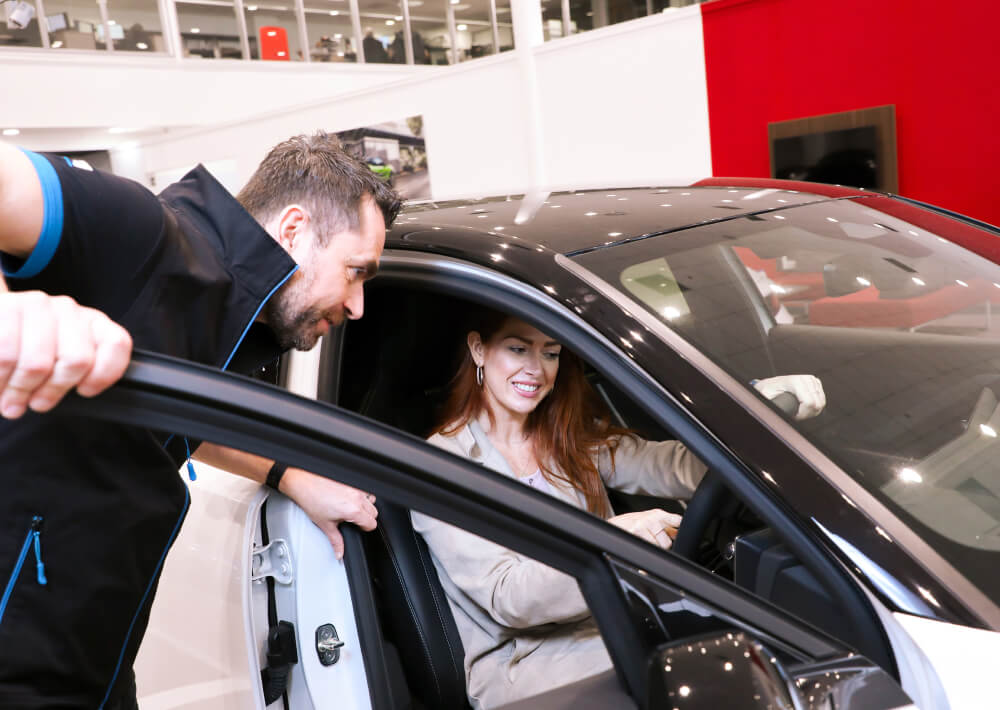 Customer in car being helped by a staff member