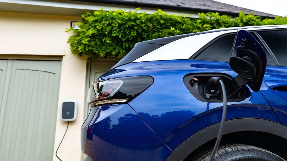 Close up view of Volkswagen vehicle charging in front of house